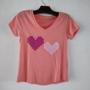 Camiseta de malha rosa com  corações de bordado filé